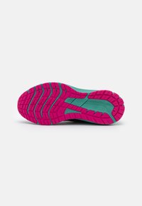 Semelle de chaussure avec une base turquoise et un motif de semelle rose, comprenant des rainures et des crampons pour une traction et une stabilité accrues.