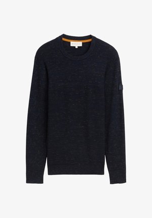 Granatowy sweter dzianinowy z okrągłym dekoltem, wzorem strukturalnym i subtelnym pomarańczowym akcentem od wewnętrznej strony kołnierza. Na rękawie znajduje się naszywka z logo marki.
