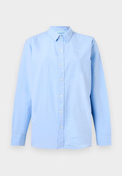 Ελαφρώς γαλάζιο πουκάμισο με μακριά μανίκια, γιακά και μικρό λευκό κεντημένο κείμενο στο αριστερό στήθος.
