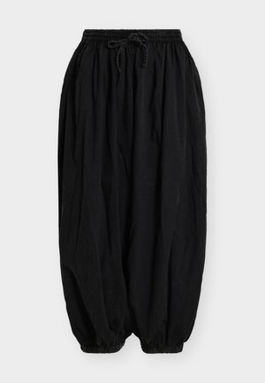 Pantaloni negri largi cu talie elastică și șnur, mansete elastice adunate la glezne, realizați dintr-un material ușor.