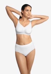 Vitt bh och högmidjade underkläder gjorda av slätt tyg. Bh:n har justerbara axelband och samlas i mitten för en säker passform.