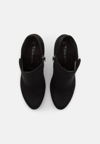 Bottines en suède noir avec une surface lisse, un bout pointu et une tige courte. Équipées d'une fermeture éclair sur le côté pour un enfilage facile. Taille 37.