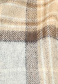 Wollkarostoff mit einem Farbschema aus Beige, Braun und Grau, versehen mit Hahnentritt- und Karomustern, weicher Textur und leichtem Glanz.