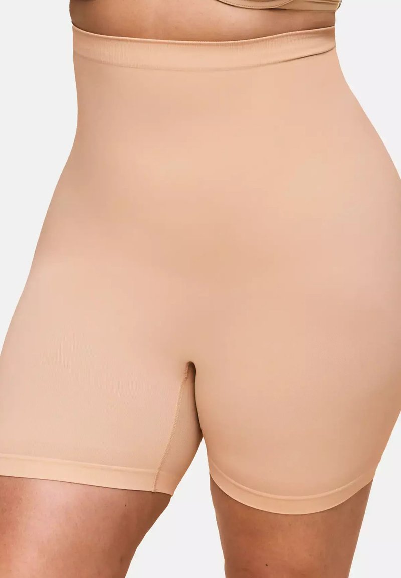 Beige shorts bis zur Taille aus glattem, dehnbarem Material. Verfügt über ein nahtloses Design und einen Schnitt bis zur Mitte des Oberschenkels, geeignet zum Tragen unter Kleidung.