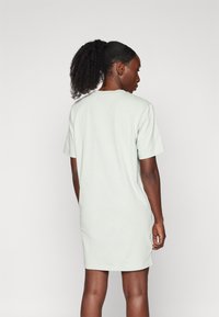 Robe courte à manches courtes verte menthe en coton doux, dotée d'une coupe décontractée et d'un col rond, sans ornements ni motifs.