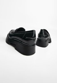Zwarte gepatineerde leren platform loafers met een gladde afwerking, voorzien van een ronde neus en een dikke, gestructureerde zool.