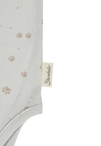 Light gray fabric with small beige paw prints and a beige tag with black cursive text "Sterntaler" on the side seam.