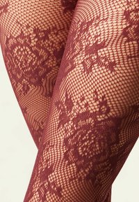 Burgundské síťované punčochy zdobené květinovým krajkovým vzorem, s texturovanou tkaninou a otevřeným síťovým designem, který zdůrazňuje jemné detaily.