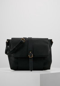 Borsa a tracolla in pelle nera con chiusura a pattina, hardware dorato, tracolla regolabile e texture liscia. Presenta un dettaglio con cucitura verticale.