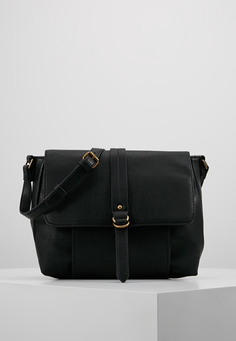 Borsa a tracolla in pelle nera con chiusura a pattina, hardware dorato, tracolla regolabile e texture liscia. Presenta un dettaglio con cucitura verticale.