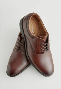 Chaussures en cuir marron avec une texture lisse, bout rond et design à lacets. Présentent une semelle cousue et une semelle intérieure rembourrée.