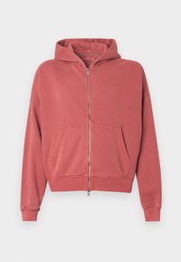 Ροζ φούτερ με φερμουάρ φτιαγμένο από μαλακό ύφασμα, διαθέτοντας κουκούλα, δύο μπροστινές τσέπες και πλέξη στα μανίκια, με άνετη εφαρμογή.