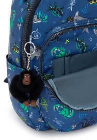 Námořnický batoh s barevnými vzory na mořské téma, vybavený přívěskem gorily z umělé kožešiny a přední kapsou s kontrastním tyrkysovým podšívkou.