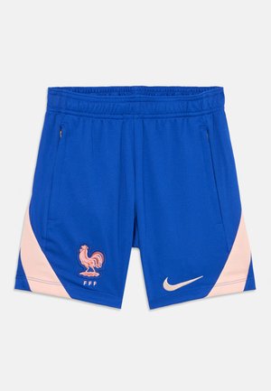 Sinised spordilühikesed püksid, mis on valmistatud tekstuursetest kangast, roosa küljeaktsent ja tikkitud kanali logo koos "FFF". Nike logo beeži värviga.