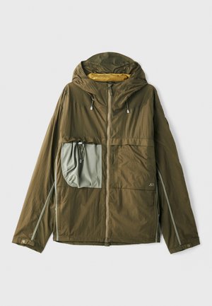 Veste légère olive avec capuche, fermeture éclair à l'avant, grande poche grise, accents réfléchissants et cordons de serrage ajustables à la capuche.
