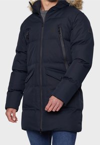 Navyblauwe gewatteerde parka-jas met een capuchon van nepbont, twee borstzakken met rits en twee knoopzakken aan de voorkant; voorzien van een stevige ritssluiting.