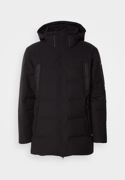 Veste noire rembourrée avec capuche, poches zippées et accents texturés sur les côtés. Le matériau semble lisse avec une finition mate.