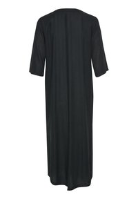 Vestido negro, a la altura de la rodilla, con un ajuste relajado, mangas cortas y cuello redondo. Confeccionado en un material ligero y suave sin patrones visibles.