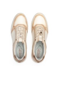 Zapatillas beige con un upper liso, paneles laterales texturizados, puntera redonda y sistema de cordones decorativo. Forro interior suave con detalle de logo.