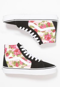 Baskets montantes en daim noir avec un motif floral en rose et vert. Semelle en caoutchouc blanche avec des lacets et des accents latéraux contrastants.