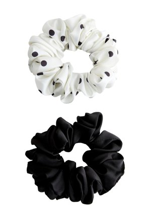 Two fabric hair scrunchies, one white with black polka dots and one solid black, both gathered in a circular shape.