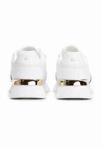 Sneaker bianche con dettagli metallici dorati sul tallone, caratterizzate da una parte superiore in pelle liscia, colletto imbottito e suola in gomma testurizzata.