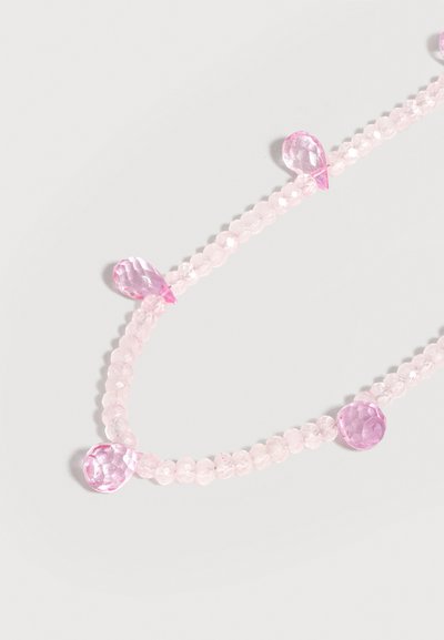 Chapelet de petites perles rondes rose pâle avec de plus grandes perles roses facettées en forme de goutte et rondes, espacées de façon intermittente.