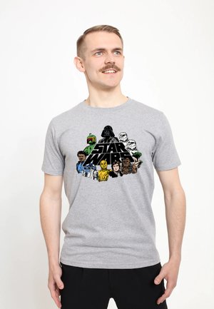 Mand iført grå Star Wars T-shirt med hovedpersoner inklusive Darth Vader, Stormtroopers, Chewbacca, C-3PO og R2-D2.