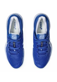 Blauwe sportieve schoenen met een mesh bovenkant, een gewatteerde kraag, textuurveters en een witte tussenzool met logo-accenten.