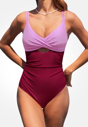 Maillot de bain une pièce avec une partie supérieure mauve, un design tordu et une section médiane découpée de couleur bordeaux. Texture lisse, bretelles ajustables.