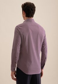 Długi rękaw w kolorze fioletowym z geometrycznym wzorem. Posiada kołnierzyk oraz mankiety zapinane na guziki. Gładki materiał z dopasowanym krojem.