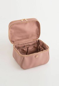 Rosa tekstureret kosmetiktaske med gylden lynlås, åbnet for at afsløre et rummeligt indre med to elastiske rum og en central skillevæg.