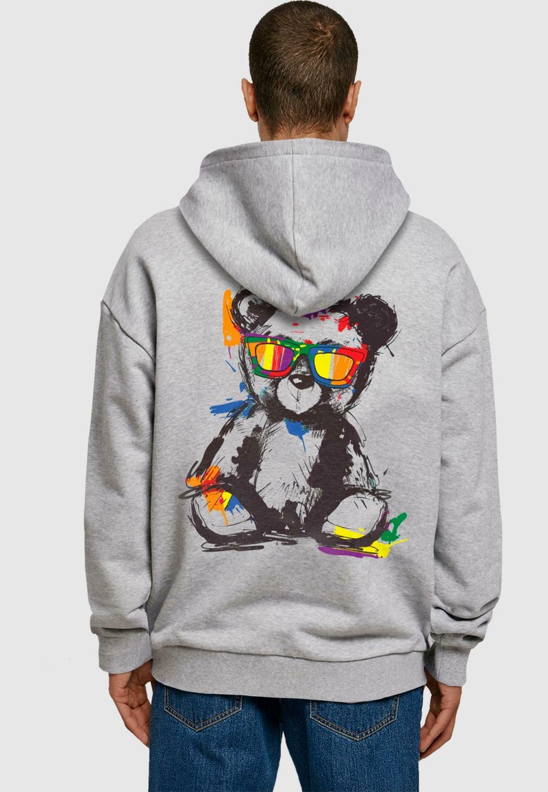 Felpa grigia in cotone con una grande grafica colorata di un orso che indossa occhiali da sole sul retro. Presenta una vestibilità comoda e polsini a coste.