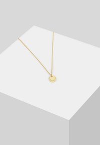 Guldring med en lille rund vedhæng med en tekstureret overflade, hængende fra en fin kæde. Enkelt design og glat finish.