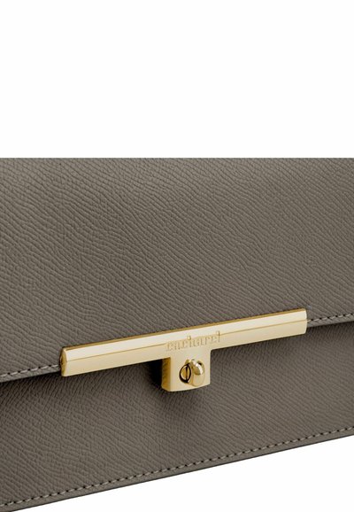 Grijze clutch van gestructureerd leer met een gouden metalen sluiting waarop "Cacharel" is gegraveerd, centraal op de klep.