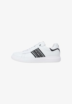 White sneaker with black stripes, textured synthetic upper, lace-up closure, and rubber sole. Features branding on the side.