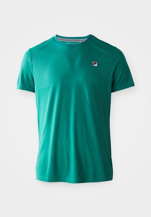 Teal kortærmet sports-t-shirt med rund hals og lille FILA-logo på venstre bryst, vist på en ensfarvet hvid baggrund.
