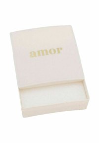 Vit rektangulär låda med rundade kanter, med ordet "amor" i guld på locket. Insidan är klädd med mjukt vitt material.