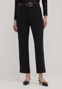 Pantaloni neri su misura con un design a gamba dritta, fondo a risvolto e una cintura con fibbia dorata per un tocco di stile. Tessuto liscio e strutturato.