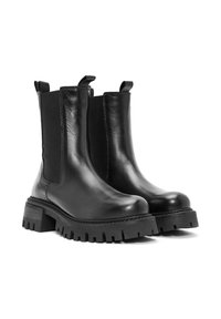 Botas Chelsea de cuero negro con suelas gruesas tipo lug, paneles laterales elásticos y lengüetas de tirón sobre un fondo blanco.
