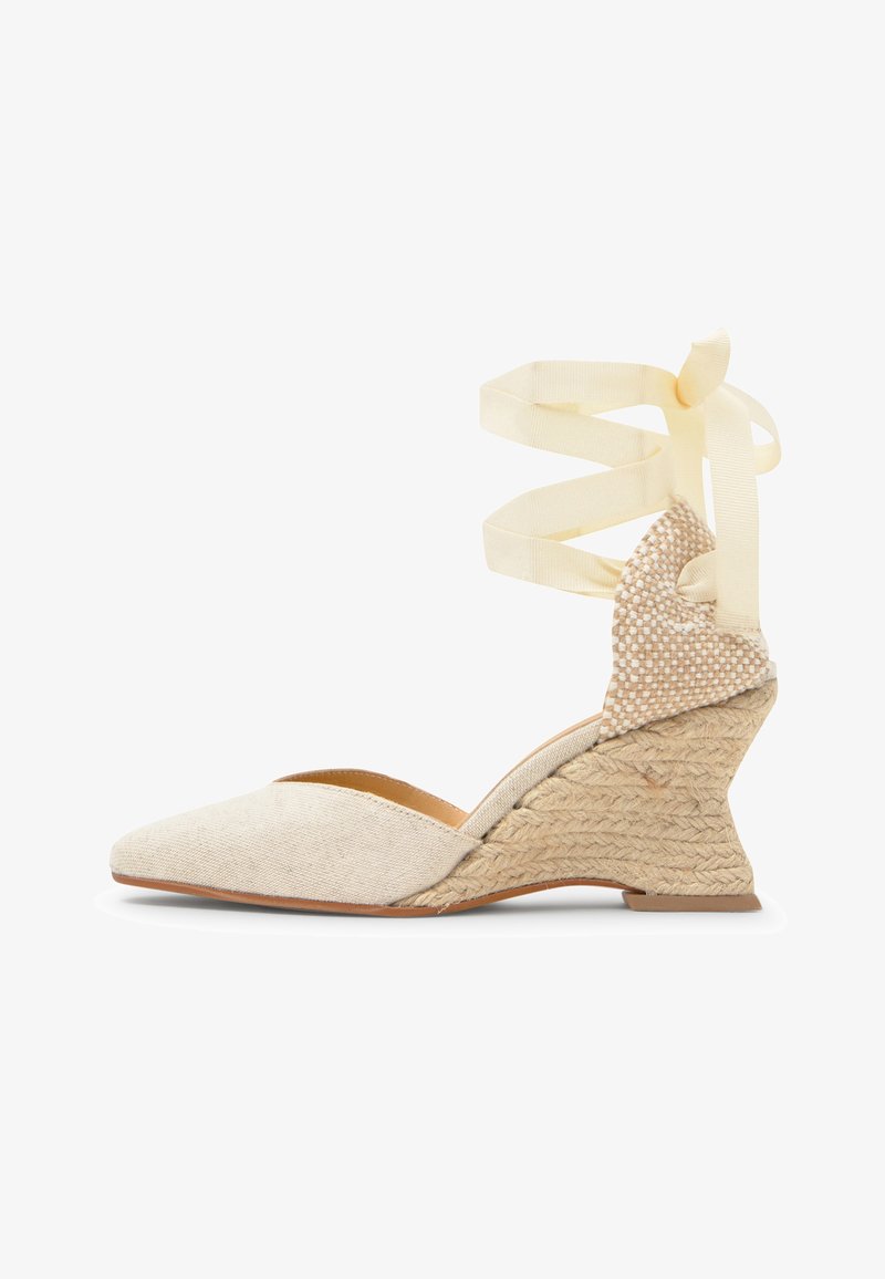 Chaussure espadrille beige à talon compensé avec bout pointu fermé, talon texturé tissé et long ruban crème à nouer autour de la cheville.