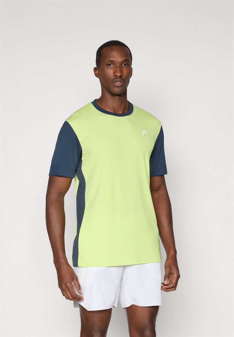 Camiseta deportiva de manga corta con un cuerpo verde lima, mangas azul marino y paneles laterales con un diseño texturizado. Logo en la parte frontal.