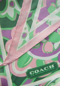 Silkkia huivi, jossa on kukkakuvio pinkin, vihreän ja purppuran sävyissä. Reunat vaaleanpunaisia ja näkyvissä "COACH Leatherware" -label.