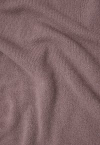 Tejido de punto en un suave color malva, que muestra un patrón texturizado con un sutil estiramiento y caída. Superficie suave con hilos finos.