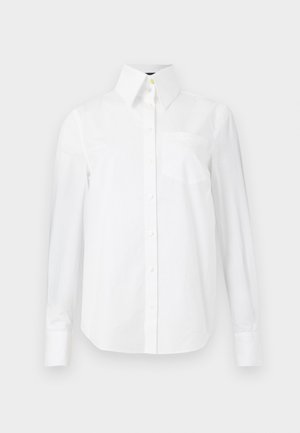 Balta kokvilnas krekls ar garām piedurknēm, ar norādītu apkakli, priekšējo kabatu un pogu aizdari. Gluda tekstūra.