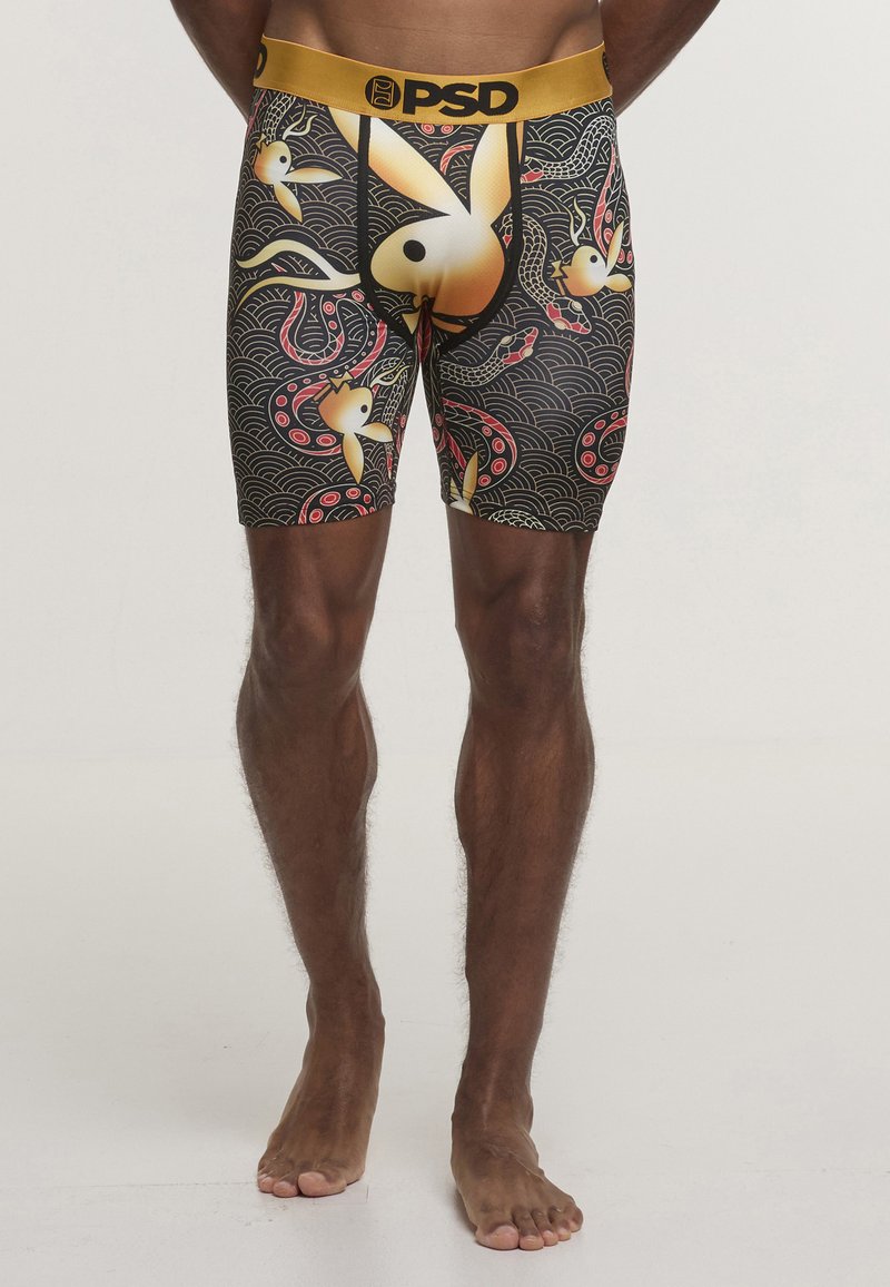 Boxer neri con motivi colorati di pesci e onde. Vita elastica dorata con logo "PSD". Tessuto morbido con design aderente.