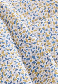 Bomuldsstof med en hvid baggrund, der har et mønster af små blade i blå, gule og grå toner, hvilket skaber et struktureret udseende.