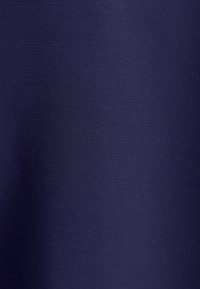 Merensininen kangas, jossa on hieno, tiiviisti kudottu rakenne ja hienovarainen varjostusgradientti pinnalla.