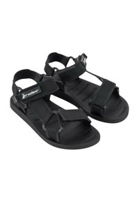 Sandali neri realizzati in materiale sintetico con chiusure a strappo regolabili, suola testurizzata e design aperto per traspirabilità e comfort.