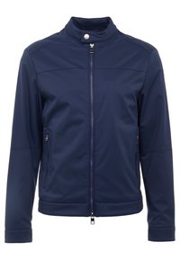 Marineblå softshell-jakke med højt krave, to sidelommer med lynlås og lynlås foran. Glat tekstur, minimalistisk design.